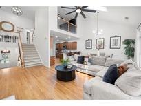 Bright living room with hardwood floors, high ceilings, and a large comfortable sectional sofa at 6403 Queens Court Trce, Mableton, GA 30126