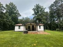 Charming, cottage-style home featuring a welcoming front porch and lush green lawn at 241 Wooten Ct, Canton, GA 30114