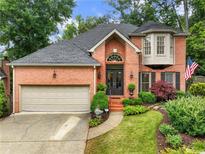 Charming two-story red brick home with well-manicured landscaping and an attached two-car garage at 350 Fountain Oaks Ln, Atlanta, GA 30342