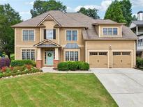 Charming two-story home featuring a manicured lawn, beautiful landscaping, and a welcoming front entrance at 3595 Millwater Xing, Dacula, GA 30019