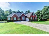 Charming single-story brick home with a well-manicured lawn and a long driveway leading to an attached garage at 2068 Tribble View Way, Lawrenceville, GA 30045