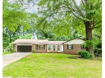 Charming single-story home featuring a brick facade, lush front lawn, and a convenient two-car garage at 3156 Laurel Way, Snellville, GA 30078