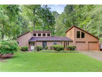 Charming home featuring a 2-car garage, well-manicured lawn, and mature trees at 4920 Tremont Ne Dr, Marietta, GA 30066