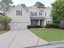 Charming home featuring a well-manicured lawn, two-car garage, and attractive architectural details at 522 Blue Mountain Rise, Canton, GA 30114