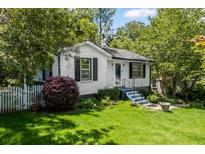 Charming single-story home with white brick, black shutters, and a well-maintained front yard with mature trees at 881 Mclinden Se Ave, Smyrna, GA 30080