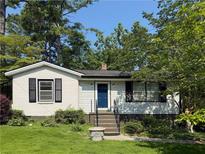 Charming one-story home with brick accents, manicured lawn and mature trees providing shade at 881 Mclinden Se Ave, Smyrna, GA 30080