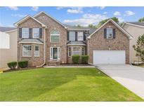 Beautiful two-story brick home with a well-manicured lawn and attached two car garage at 4474 Michael Jay St, Snellville, GA 30039