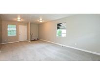 Bright living room featuring neutral paint, carpeted floor, and natural light from the windows at 1079 Stonewall Drive Southeast, Atlanta, GA 30315