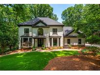 Charming two-story home featuring a manicured lawn and lush, mature landscaping at 210 Hunters Vw, Roswell, GA 30075