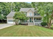 Charming two-story home with a welcoming front porch, manicured lawn, and lush landscaping at 3158 Crestmont Nw Way, Kennesaw, GA 30152