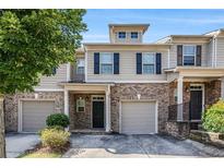 Charming townhome featuring a brick facade, gray siding, and attached one-car garage at 2725 Morgan Glen Rd, Buford, GA 30519