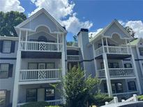 Exterior view of gray condos with white trim and balconies, set against a blue sky with fluffy clouds at 3515 Shepherds Path, Decatur, GA 30034