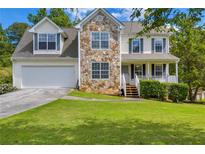 Charming two-story home featuring stone accents, a well-manicured lawn, and an attached two-car garage at 684 Doe Lane Ln, Loganville, GA 30052