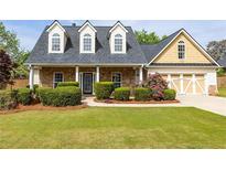 Charming, two-story home boasts stone accents, a well-manicured lawn, and a cozy, inviting front porch at 3012 Keeneland Blvd, Mcdonough, GA 30252