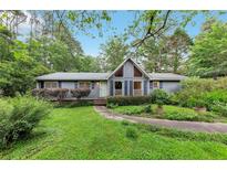 Charming single-story home with a well-manicured lawn, lush landscaping, and inviting curb appeal at 2736 Whisper Trl, Douglasville, GA 30135
