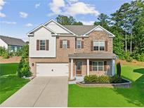 Inviting two-story home featuring brick and siding exterior, manicured lawn, and a two-car garage at 3962 Roberts Crest Dr, Suwanee, GA 30024