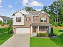 Charming two-story home with brick and siding, complemented by a well-manicured lawn and a two-car garage at 3962 Roberts Crest Dr, Suwanee, GA 30024