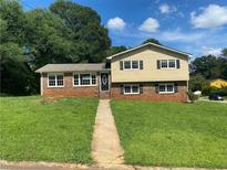Charming two-story home with a lush green lawn and inviting curb appeal under a partly cloudy sky at 5114 Rock Eagle Dr, Stone Mountain, GA 30083