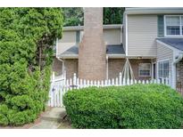 Charming townhome featuring a brick chimney and a lovely fenced front yard with lush greenery at 563 Trillum Sw Ct # 563, Marietta, GA 30008