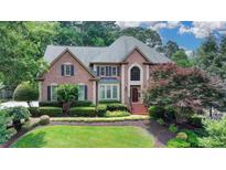Stately brick home with manicured lawn and mature landscaping offering classic curb appeal at 10195 Brier Mill Ct, Alpharetta, GA 30022