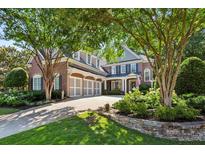 Stately brick home with a three-car garage, manicured landscaping, and mature trees providing shade at 1382 Murrays Loch Nw Pl, Kennesaw, GA 30152