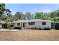 Charming single-story home with a white brick exterior, covered parking, and a well-maintained front yard at 4237 Rickenbacker Ne Way, Atlanta, GA 30342