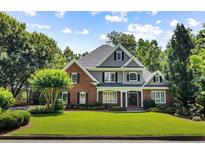 Beautiful two-story home with lush green lawn, manicured landscaping, and a classic brick and gray exterior at 125 Franklin Pl, Atlanta, GA 30342