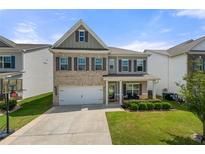 Charming two-story home featuring a brick facade, covered porch, and well-manicured lawn at 1570 Ribbon Mill Sw Ln, Mableton, GA 30126