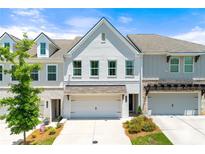 Charming townhome with a two-car garage, landscaped yard, and attractive architectural details at 1316 Willamette Way, Marietta, GA 30008