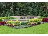 Landscaped Cross Creek community entrance sign with manicured plants and lush greenery at 37 La Rue Nw Pl, Atlanta, GA 30327