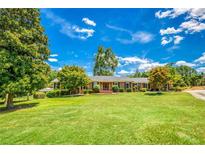 Beautiful home with mature trees, manicured lawn, and charming curb appeal on a sunny day at 3700 Tom Brewer Rd, Loganville, GA 30052