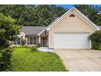 Charming, single-story home with a two-car garage, tidy lawn, and mature trees at 1055 Avalon Dr, Lawrenceville, GA 30044