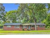 Charming brick ranch-style home with well-maintained lawn and mature trees at 1189 E Fayetteville Rd, Riverdale, GA 30296