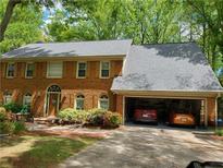 Charming two-story brick home with attached two-car garage and mature landscaping at 10815 Tuxford Dr, Alpharetta, GA 30022