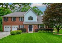 Charming two-story brick home with a well-manicured lawn and a two car garage at 10980 Pinehigh Dr, Alpharetta, GA 30022