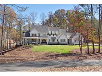 Stunning white house with manicured lawn and professionally landscaped grounds at 113 Laurel Brook Ln, Canton, GA 30115