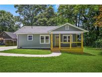 Charming home featuring a covered porch, well-kept lawn, and classic design with a modern exterior paint and ample natural light at 1675 White Oak Way, Decatur, GA 30032