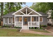 Charming gray home features a welcoming front porch with a swing, complemented by a well-manicured lawn at 814 S Mcdonough St, Decatur, GA 30030