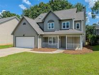 Charming two-story home with a well-manicured lawn and a welcoming front porch and attached garage at 1904 Watercrest Cir, Lawrenceville, GA 30043