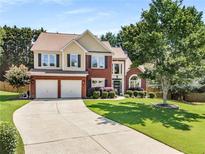 Charming two-story home with a well-manicured lawn, complemented by a two-car garage and inviting brick facade at 2740 Greymont Ct, Cumming, GA 30041