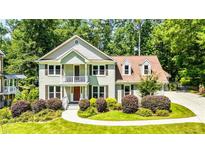 Charming two-story home featuring a well-manicured lawn, brick facade, and inviting front porch at 115 Edgewater Way, Peachtree City, GA 30269