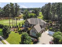 Stunning two-story brick home featuring a golf course view, lush landscaping, and a spacious driveway at 2380 Tayside Nw Xing, Kennesaw, GA 30152