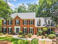Elegant brick home featuring a symmetrical design, black shutters, and lush landscaping at 3506 Billingsley Dr, Marietta, GA 30062