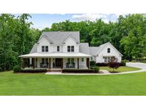Stunning two-story modern farmhouse with a welcoming front porch and professionally landscaped lawn at 2101 Thomas Rd, Canton, GA 30115