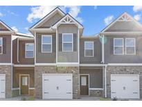 Charming townhome exterior with neutral siding, brick accents, and attached one-car garage at 229 Ivey Ter # 37, Temple, GA 30179