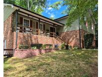 Charming home with brick and siding, complemented by a covered porch and nicely landscaped front yard at 4094 Carlisle Pl, Stone Mountain, GA 30083