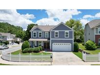 Charming two-story home with a well-manicured lawn and white picket fence at 4003 Coachman Ct, Cumming, GA 30040