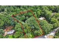 An aerial view depicts the property lines encompassing a verdant, tree-filled landscape at 980 Hightower Trl, Sandy Springs, GA 30350