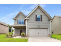Charming two-story home with gray siding, a well-manicured lawn, and an attached two-car garage at 1212 Ithaca Dr, Mcdonough, GA 30253