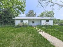 Quaint single story home with a white exterior and a well manicured front lawn at 14367 Fincher Rd, Canton, GA 30114